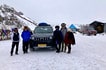 Group of tourists with driver and car, Khardung La pass with snow, winter in Ladakh