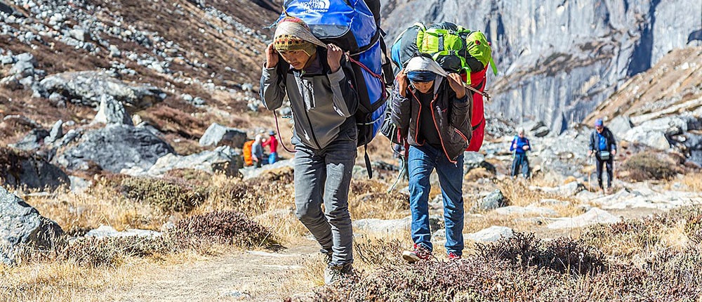 Paching tips for a trek in the Himalayas, porters with heavy bags in Nepal