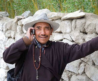 Ladakhi man with cell phone in a village, Leh, Ladakh