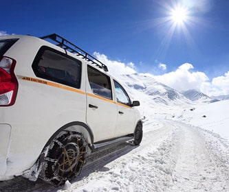 Car on a road covered with snow, high-altitude mountain pass Leh-Manali road, Ladakh