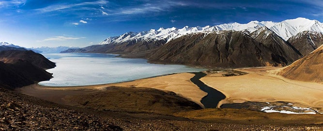 High-altitude lake surrounded by snow-clad mountains, Ladakh