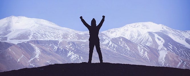 Silhouette of a person in front of snow-capped mountains, Ladakh