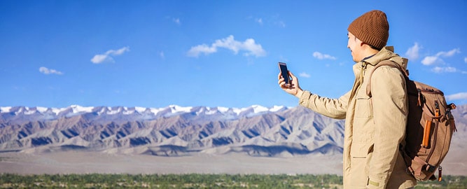Tourist trying to catch the network with his mobile phone, Leh, Ladakh