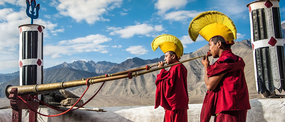 Monks blowing ceremonial trumpets in a monastery, Ladakh